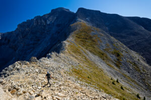 Hiker in the foreground on the trail leading up to Cascade Mountain.