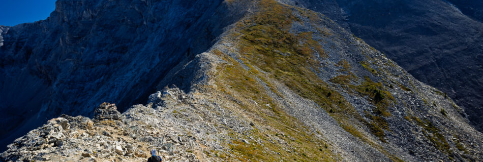 Hiker in the foreground on the trail leading up to Cascade Mountain.